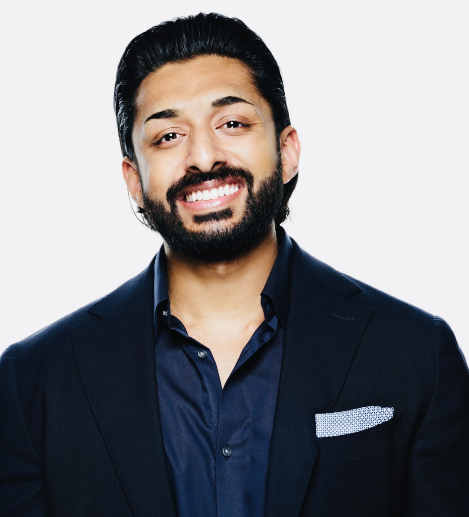 Smiling bearded person wearing a dark suit