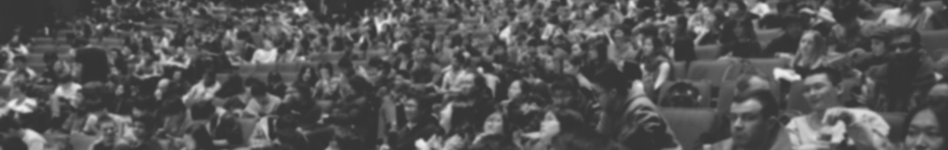 Audience seated in a large lecture hall during an academic event