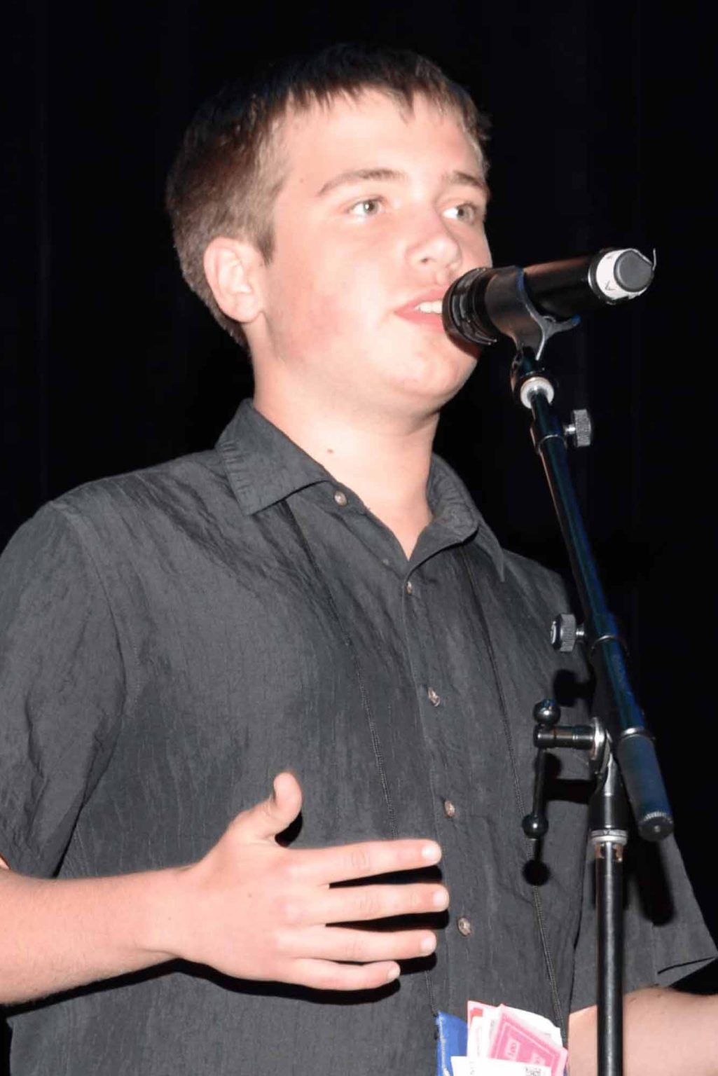 Young participant speaking into a microphone onstage